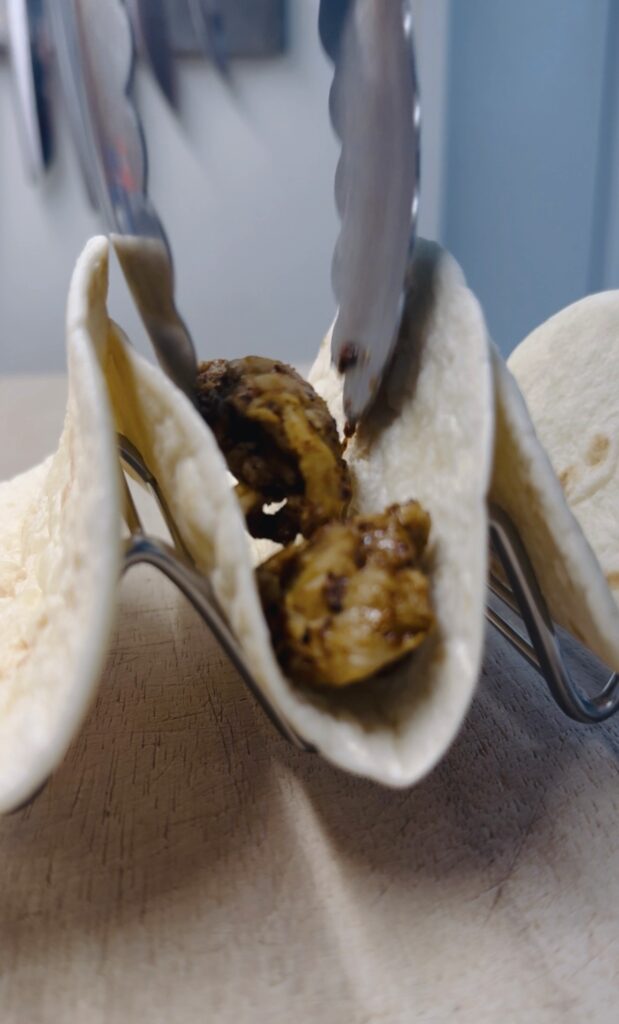 adding chicken to tacos