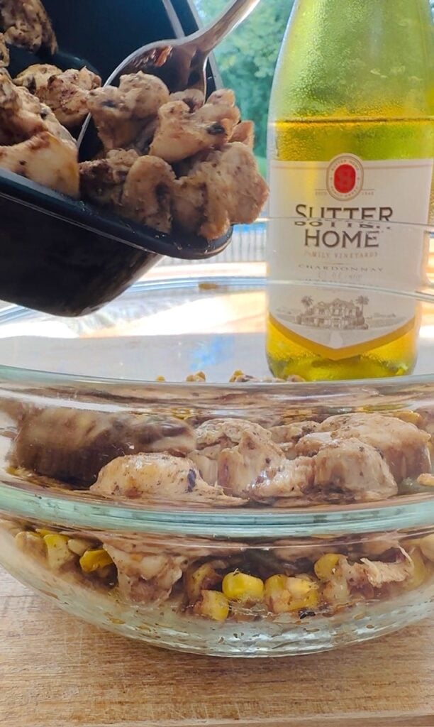 adding chicken to the salad