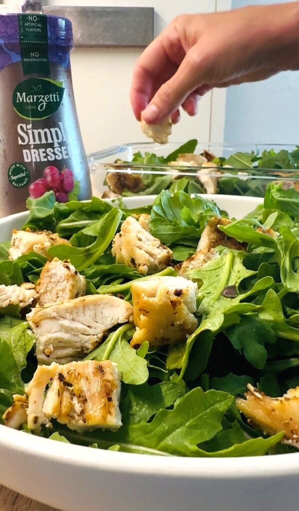 adding chicken to the salads