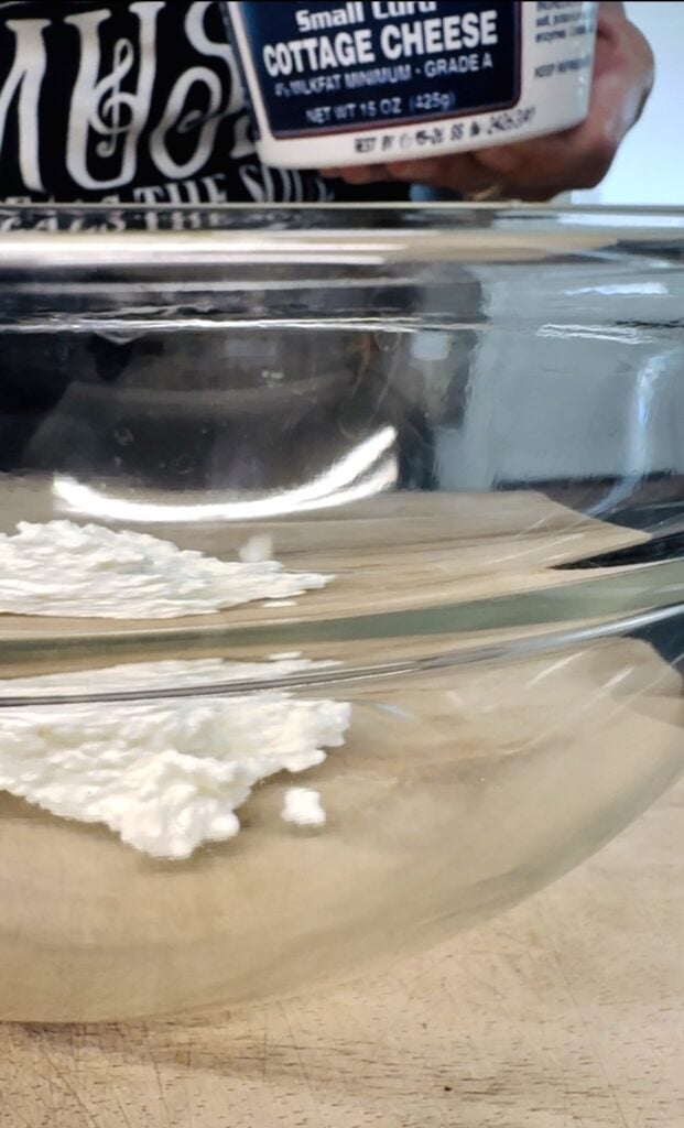 adding cottage cheese to a bowl