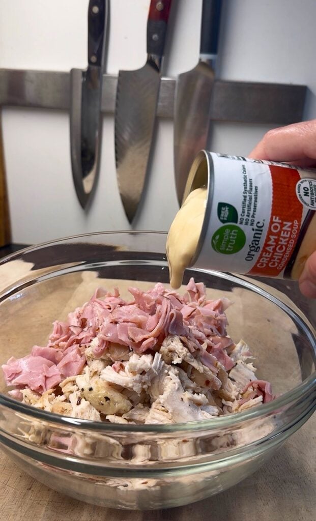 adding cream of chicken soup to bowl