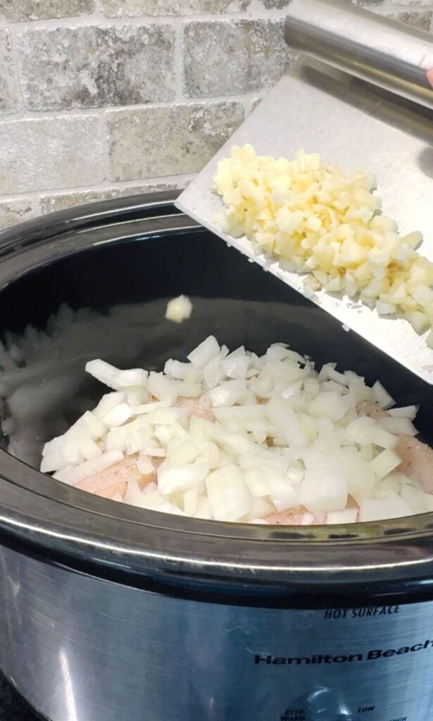 adding garlic to the soup